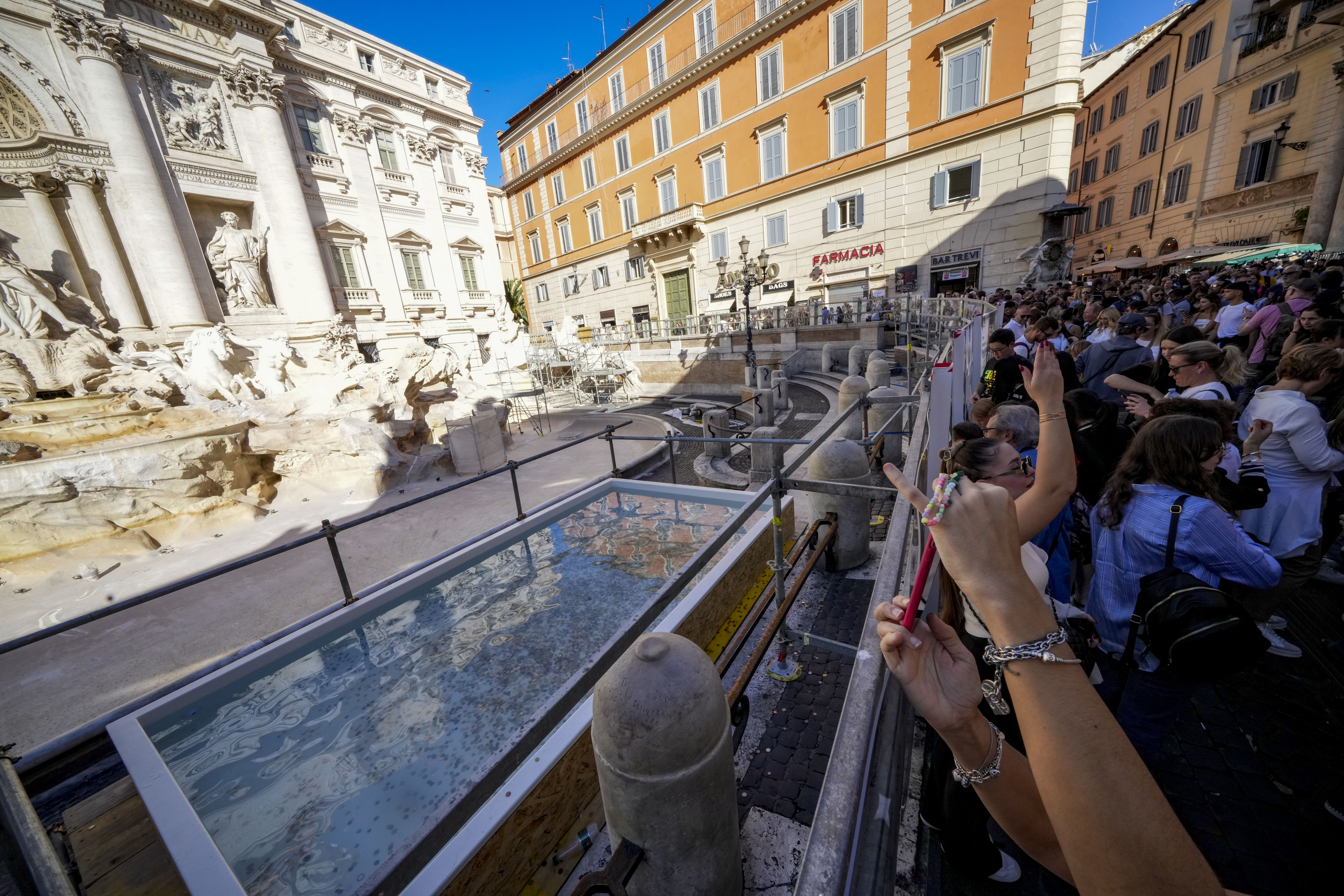 A small pool is seen in front of the Trevi Fountain to allow tourists to throw their coins in it, as the fountain has been emptied to undergo maintenance work that it is expected to be completed by the end of the year, in Rome, Friday, Nov. 1, 2024. (AP Photo/Andrew Medichini)