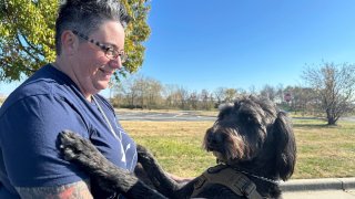 Air Force Staff Sgt. Heather O'Brien holds her labradoodle service dog