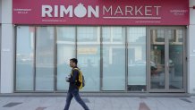 A man walks past Rimon Market, a Kosher grocery store managed by the late Rabbi Zvi Kogan