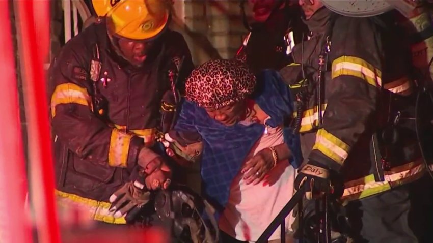 A woman is rescued from a burning rowhome in Philly's West Oak Lane neighborhood on Sunday, Nov. 17, 2024.