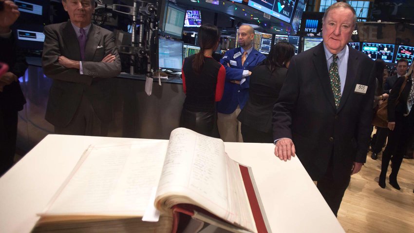 Arthur Cashin, Lead Floor Broker of UBS Financial Services, poses for a photo with the New York Stock Exchange Constitution book in New York December 30, 2014.