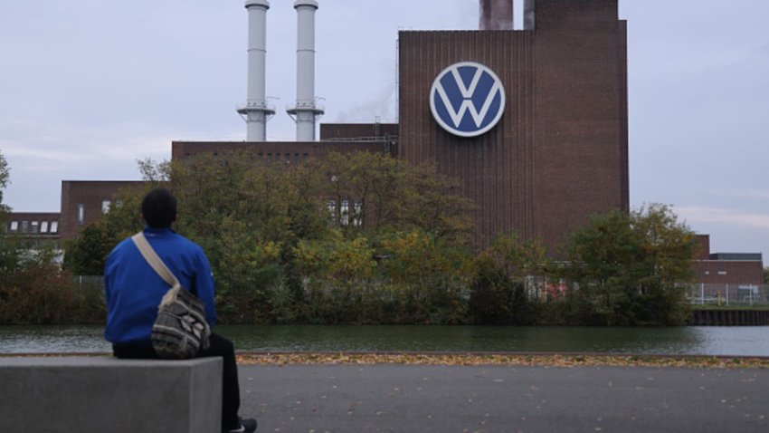 A man sits across from the Volkswagen factory on October 28, 2024 in Wolfsburg, Germany.