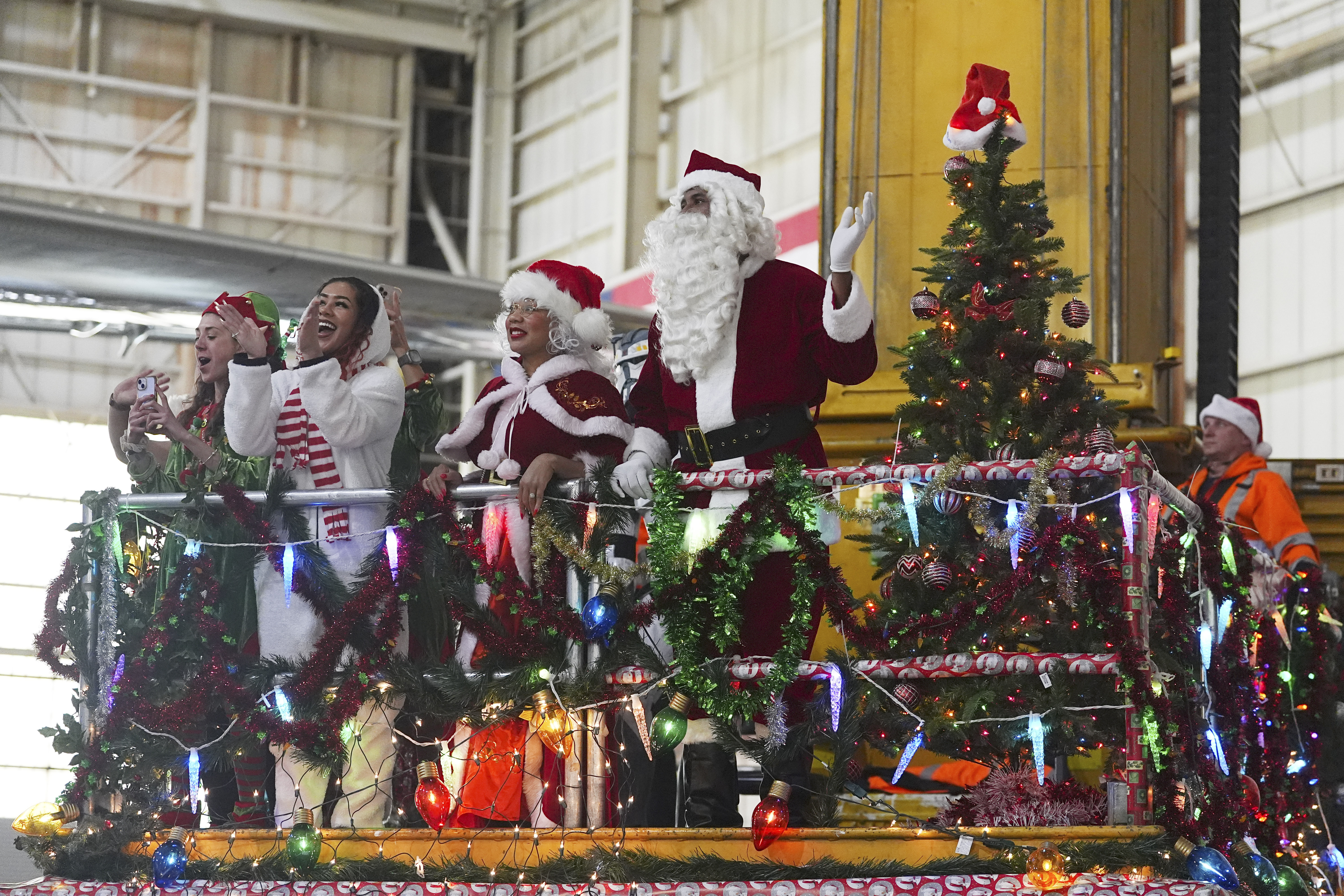 People dressed as Santa Claus and Mrs. Claus greet participants as they disembark from a plane during the United Airlines annual "fantasy flight" to a fictional North Pole at Denver International Airport, Saturday, Dec. 14, 2024, in Denver. (AP Photo/David Zalubowski)