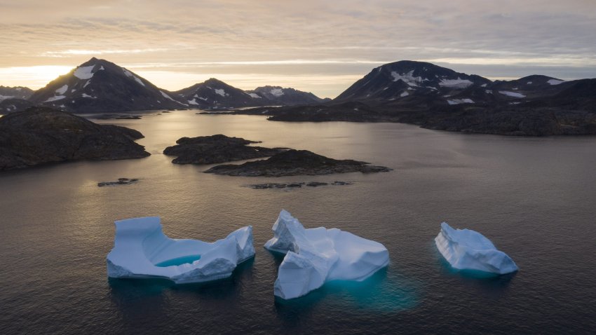 Large Icebergs float away as the sun rises near Kulusuk, Greenland