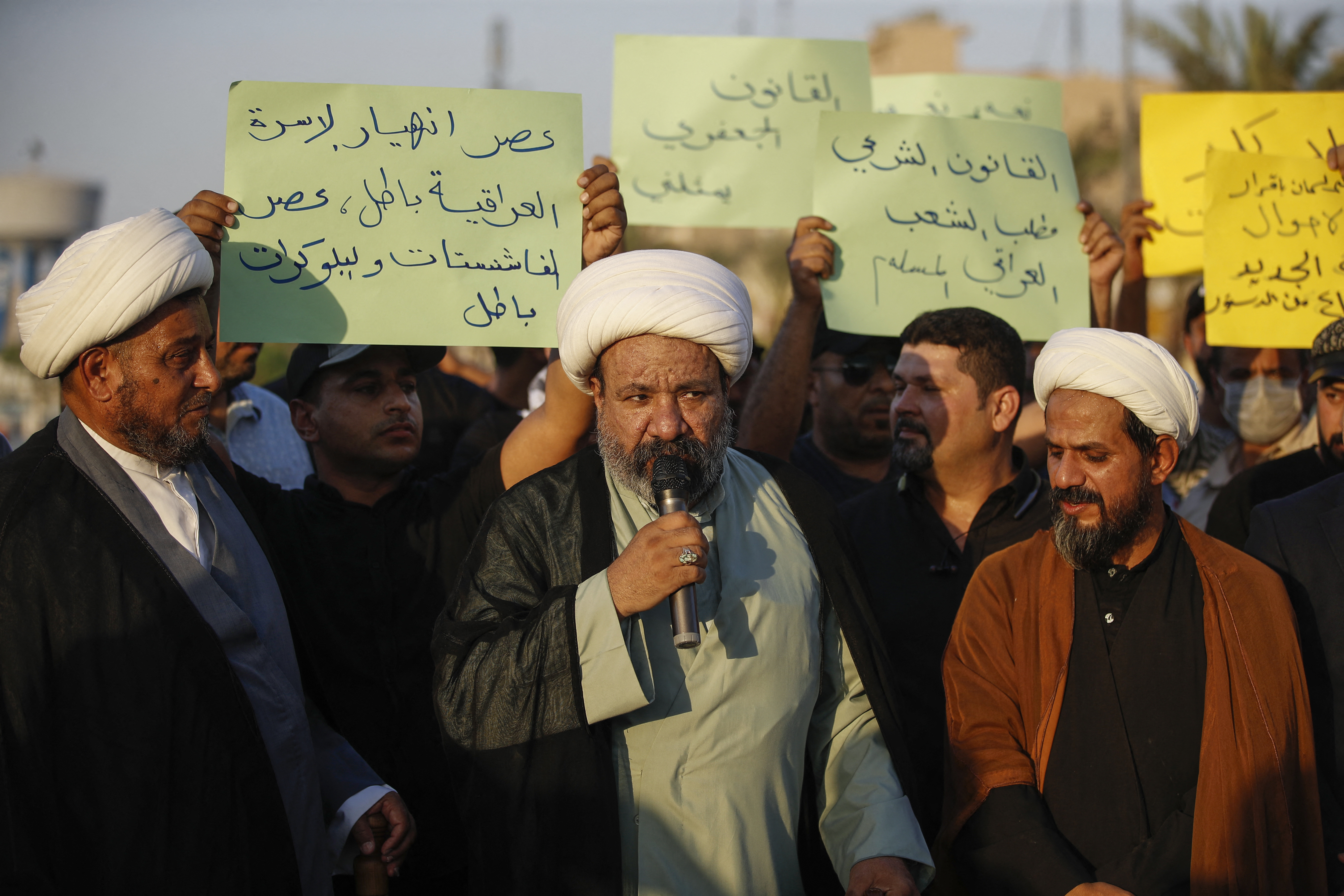 Protesters lift placards expressing support for a proposed amendment to the Iraqi Personal Status Law under discussion at the Parliament, during a rally in Tahrir Square in central Baghdad on September 8, 2024. Rights advocates are alarmed by the bill, which would allow citizens to choose either religious authorities or the civil judiciary to decide on family affairs, saying it would roll back women's rights and increase underage marriage in the deeply patriarchal society. (Photo by AHMAD AL-RUBAYE / AFP) (Photo by AHMAD AL-RUBAYE/AFP via Getty Images)