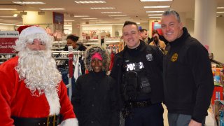 Santa (Upper Darby Superintendent Tim Bernhardt) joins a student at Stonehurst Hills Elementary School, Upper Darby Police officer Tim Fash and Mark O'Connor, the Executive Director of Families Behind the Badge during the event on Sunday.