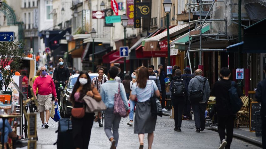 Pedestrians wear protective face masks while passing stores and cafes on Rue Montorgueil in Paris, France, on Wednesday, Aug. 26, 2020.