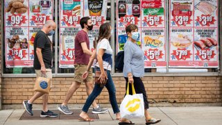 People wear face masks outside a supermarket on the Upper West Side in New York City.