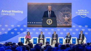 US president Donald Trump appears on a giant screen as he adresses Donald Trump global elites via video conference at the World Economic Forum in Davos on January 23, 2025.