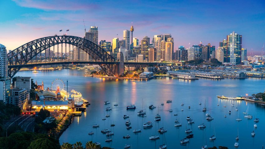 Cityscape image of Sydney, Australia with Harbor Bridge and Sydney skyline during sunset. Vacation and travel in Australia.