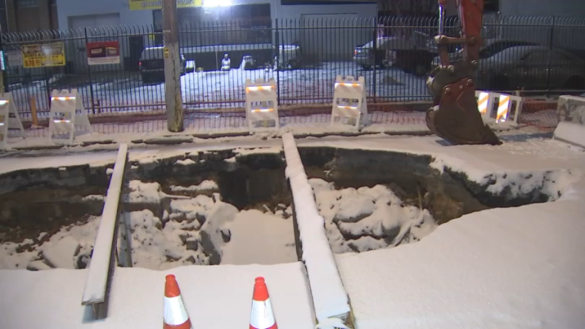 Snow covered hole in street