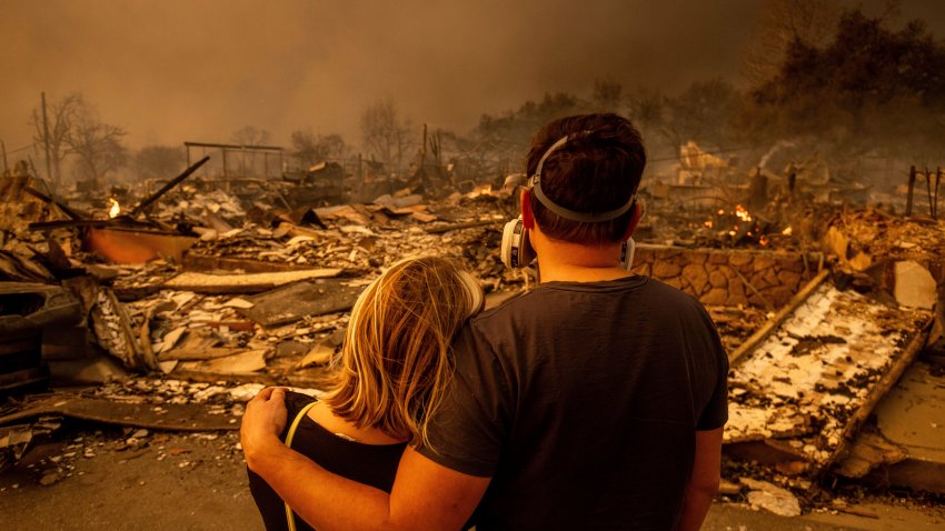 A couple looks at their fire-damaged home