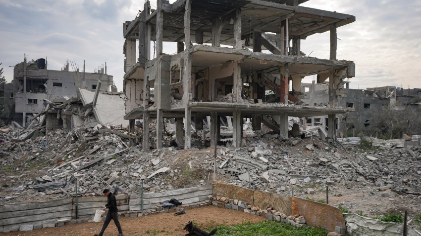 A Palestinian walks past destroyed residential buildings damaged by the Israeli air and ground offensive in Bureij, central Gaza Strip, Wednesday, Jan. 22, 2025.