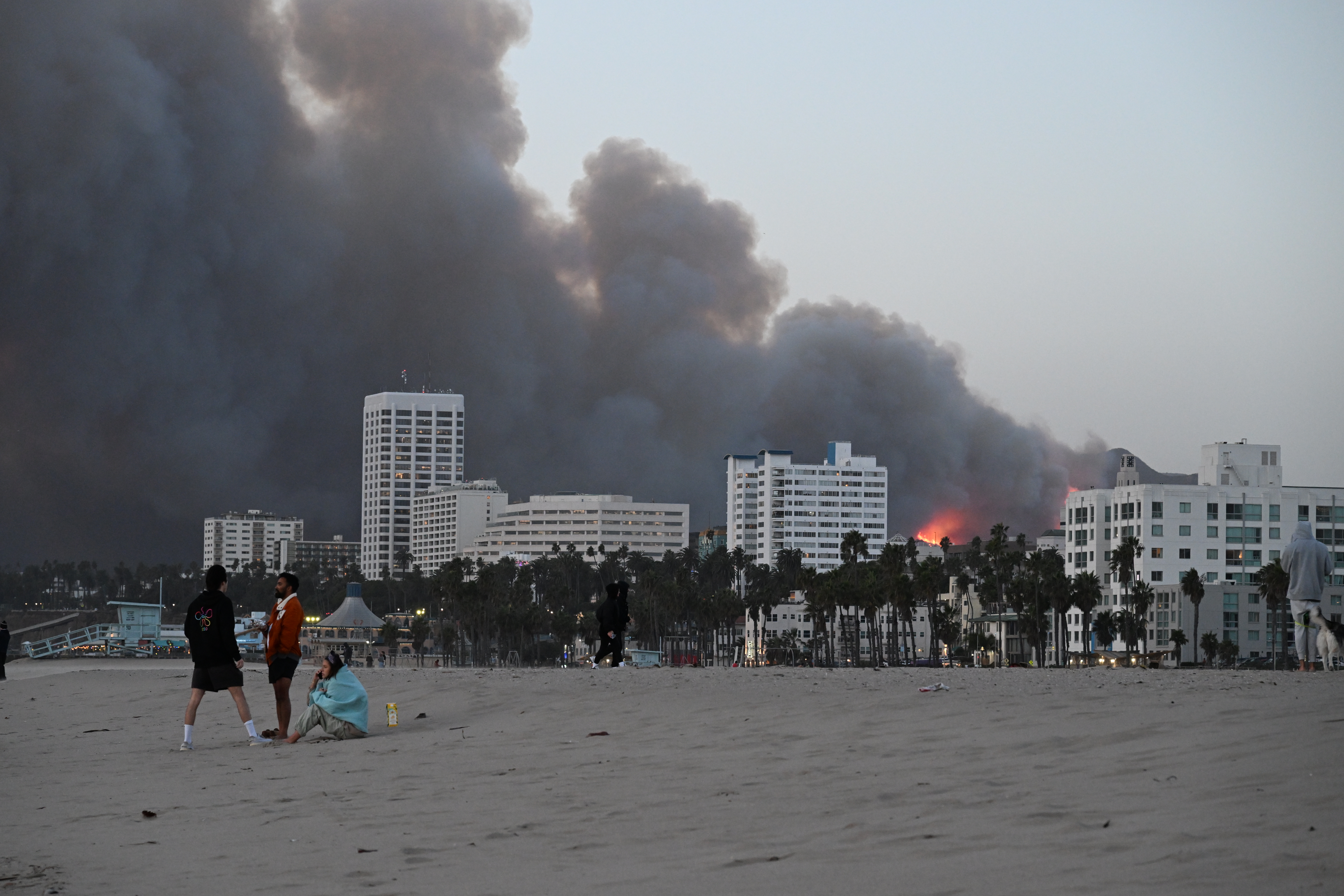 LOS ANGELES, CALIFORNIA – JANUARY 07:   Smoke and fire from the Palisades Fire fills the Santa Monica skyline as seen from Santa Monica Beach on January 07, 2025 in Los Angeles, California.  (Photo by Michael Kovac/Getty Images)