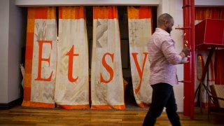 An employee walks past a quilt displaying Etsy Inc. signage at the company’s headquarters in the Brooklyn.
