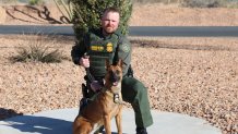 In this undated and unknown location photo released by the Department of Homeland Security shows Border Patrol Agent David Maland posing with a service dog. (Department of Homeland Security via AP)