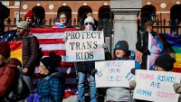 Demonstrators hold signs supporting transgender rights