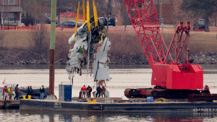 ARLINGTON, VIRGINIA – FEBRUARY 03: A large portion of the damaged plane fuselage is lifted from the Potomac River during recovery efforts after the American Airlines crash on February 03, 2025 in Arlington, Virginia. An American Airlines flight from Wichita, Kansas collided midair with a military Black Hawk helicopter while on approach to Ronald Reagan Washington National Airport on January 29, 2025 outside of Washington, DC. According to reports, there were no survivors among the 67 people onboard both aircraft. (Photo by Chip Somodevilla/Getty Images)