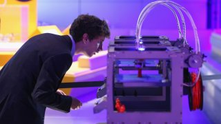A technician checks on a 3D printer as it constructs a model human figure in the exhibition ‘3D: printing the future’ in the Science Museum on October 8, 2013 in London, England.