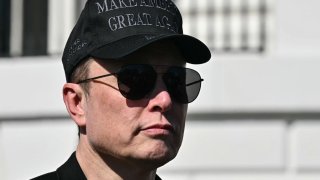 Tesla CEO Elon Musk looks on as US President Donald Trump speaks to the press as they stand next to a Tesla vehicle on the South Portico of the White House on March 11, 2025 in Washington, DC.