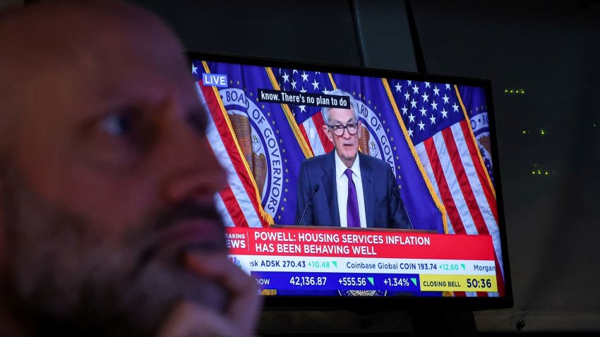 A trader works, as a screen broadcasts a news conference by U.S. Federal Reserve Chair Jerome Powell following the Fed rate announcement, on the floor of the New York Stock Exchange in New York City, U.S., March 19, 2025. 