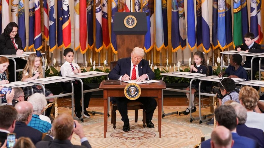 U.S. President Donald Trump signs an executive order to shut down the Department of Education, during an event in the East Room at the White House in Washington, D.C., U.S., March 20, 2025. 