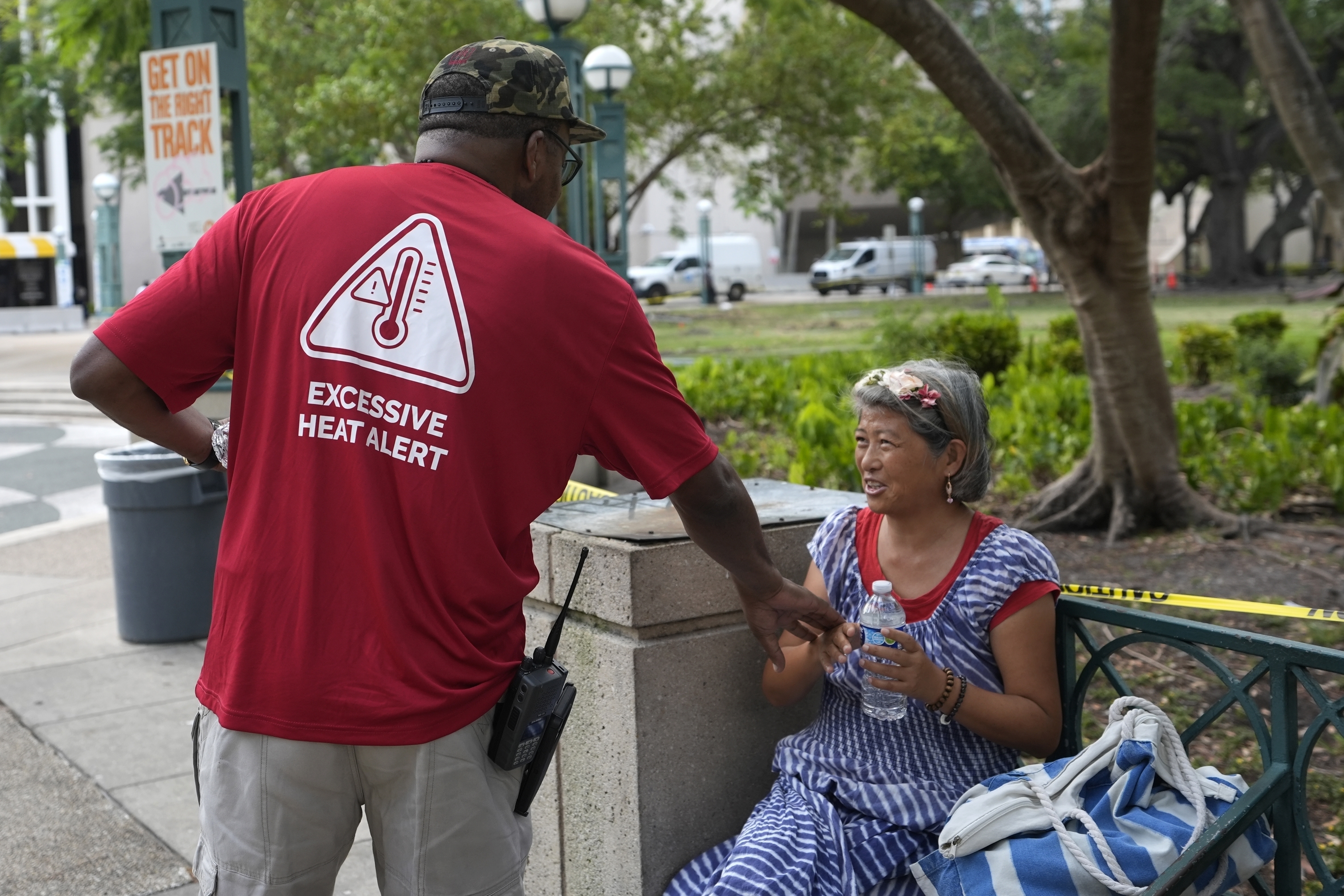 Ricky Leath, an outreach specialist with the City of Miami, talks with Bei Zhao, right