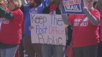Postal workers holding up signs