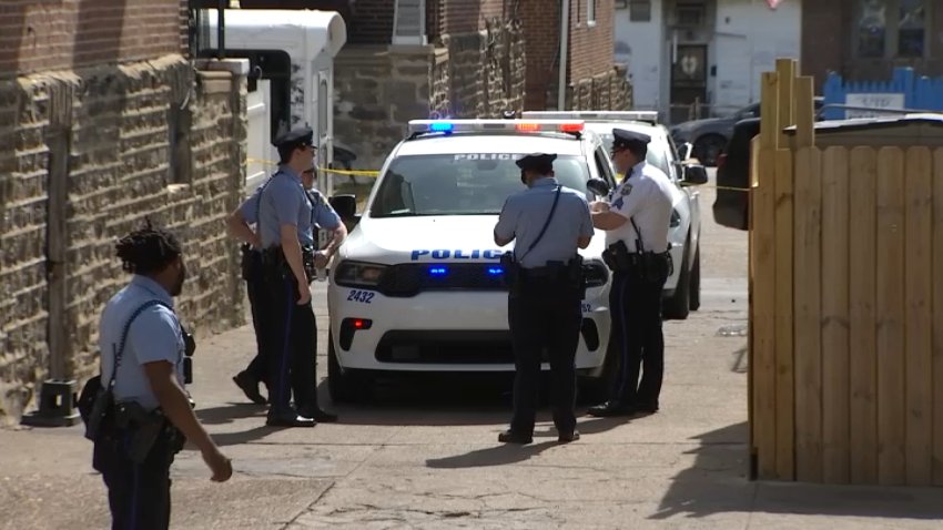 Police vehicles and officers in alley