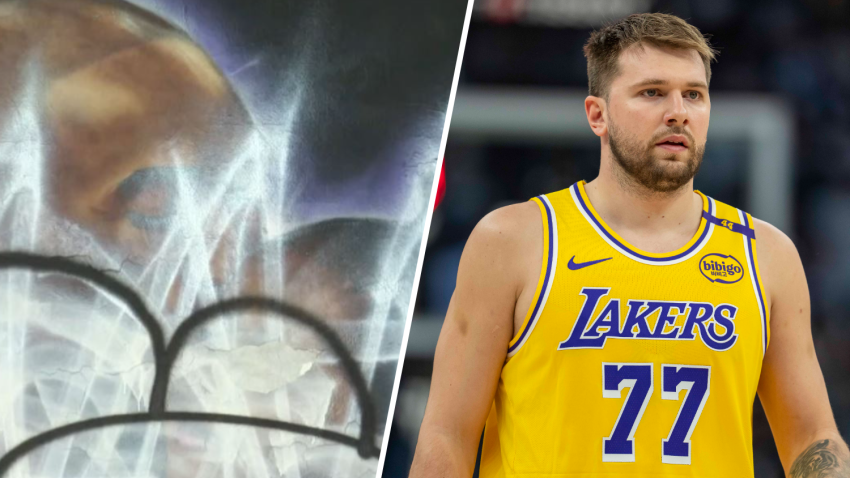 Luka Doncic is pictured (right) next to a vandalized mural of Kobe and Gianna Bryant.
