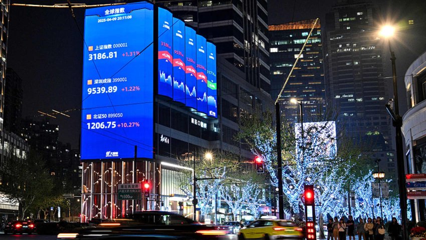 A screen showing the Shanghai composite index (top), Shenzhen component index (C) and Beijing stock exchange 50 index (bottom) in Jing’an district in Shanghai on April 9, 2025. 