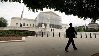 A person walks past the U.S. Supreme Court in Washington, D.C., U.S., April 21, 2025.