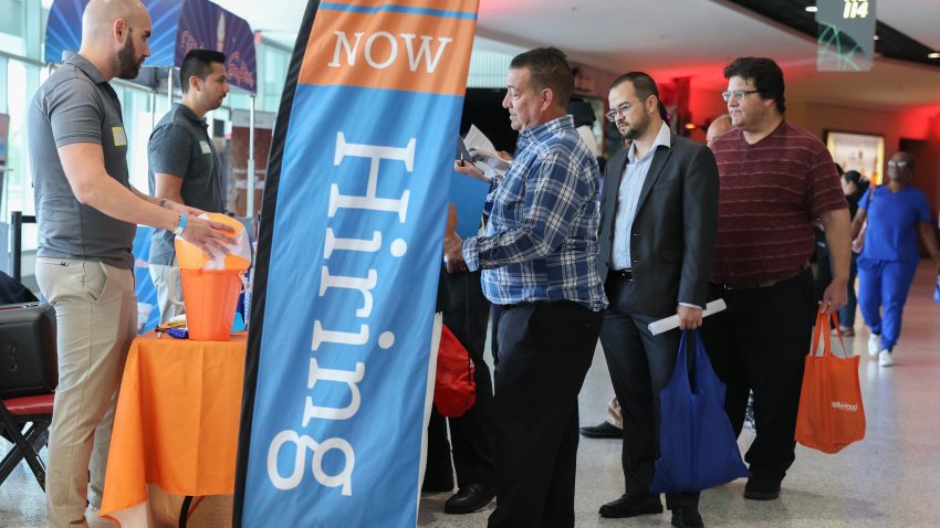 Steven Chechette (C) speaks with a recruiter at the KeySource booth at the Mega JobNewsUSA South Florida Job Fair held in the Amerant Bank Arena on April 30, 2025, in Sunrise, Florida.