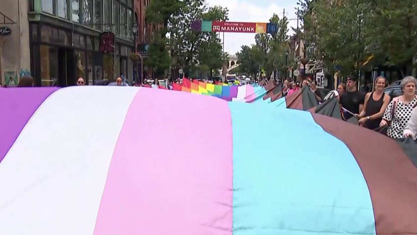 People wave large Pride flag