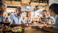 Cheerful business colleagues talking about something funny on a lunch break in a restaurant.