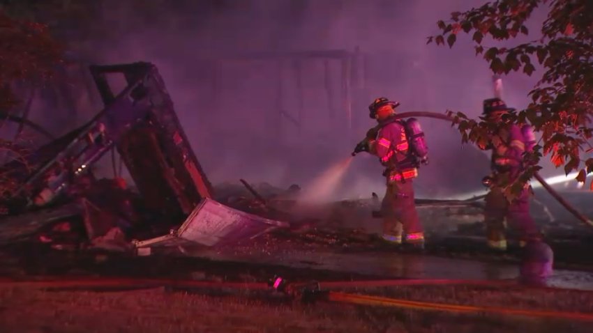 Fire crews extinguish a fire in the debris of a home that exploded in Washington Township, New Jersey, early Sunday, May 11, 2025.