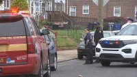 Fire and police vehicles along with investigators on street.
