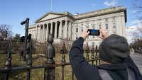 A man takes a photo of the U.S. Treasury building in Washington, January 20, 2023.