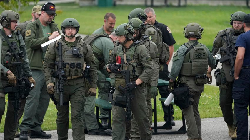 Law enforcement officers with the River Valley Tactical Team, prepare to visit the home of Vance Luther Boelter, who officials describe as a person of interest in the killing of Rep. Melissa Hortman and her husband, and the shooting of Sen. John Hoffman, near Green Isle, Minn., Saturday, June 14, 2025.