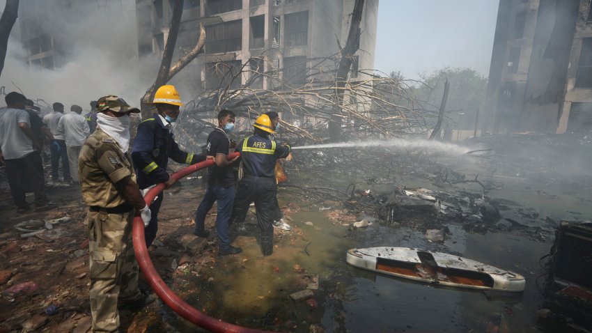 Firefighters work at the site of an airplane that crashed in India's northwestern city of Ahmedabad in Gujarat state, Thursday, June 12, 2025.
