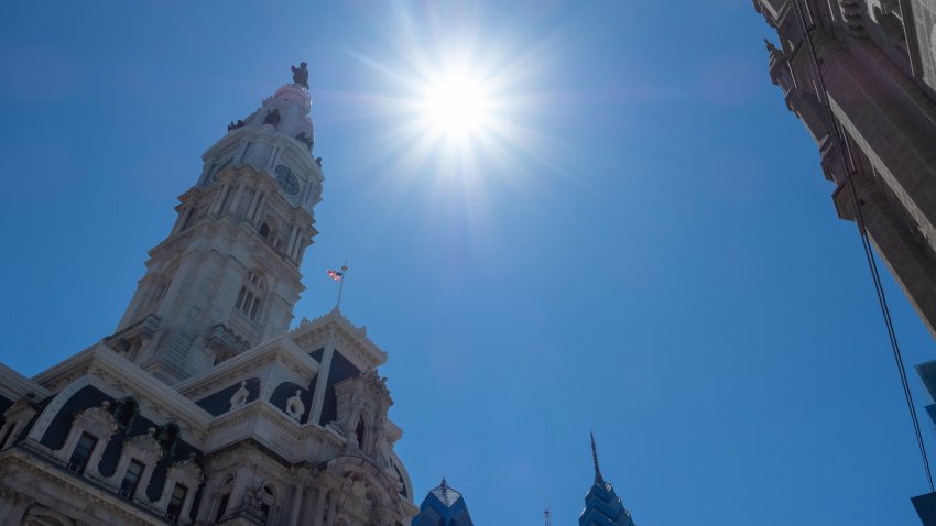 A bright shining sun near the city hall and the surrounding skyline of Philadelphia.