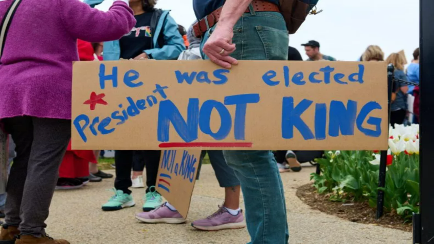 A protester attending a "Hands Off" protest in Washington, D.C. holds a sign that reads "He was elected president NOT KING" on April 5, 2025.