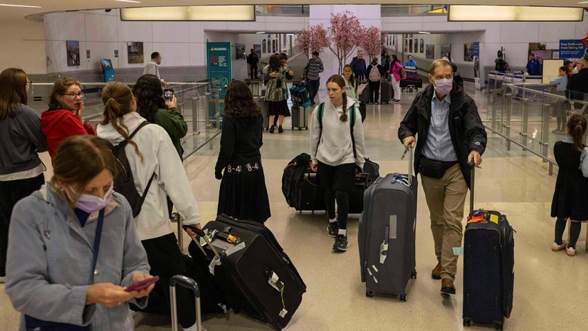 People carrying suitcases arrive from international flight at Newark Liberty International Airport, Monday, June 9, 2025, in New Jersey.
