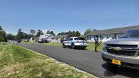 Police cars and a Delaware State Trooper on the street of a neighborhood.
