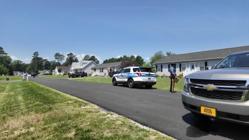 Police cars and a Delaware State Trooper on the street of a neighborhood.
