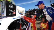Joey Logano, driver of the No. 22 Ford, has a guest from the JL Kids Crew place the winner sticker on his car in victory lane