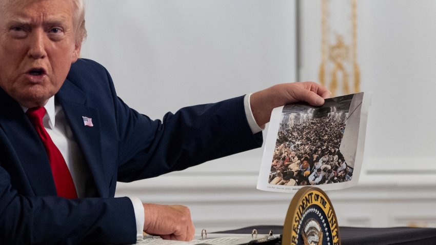 President Donald Trump holds up a photograph as he speaks to reporters after speaking to troops via video from his Mar-a-Lago estate on Thanksgiving, Thursday, Nov. 27, 2025, in Palm Beach, Fla.