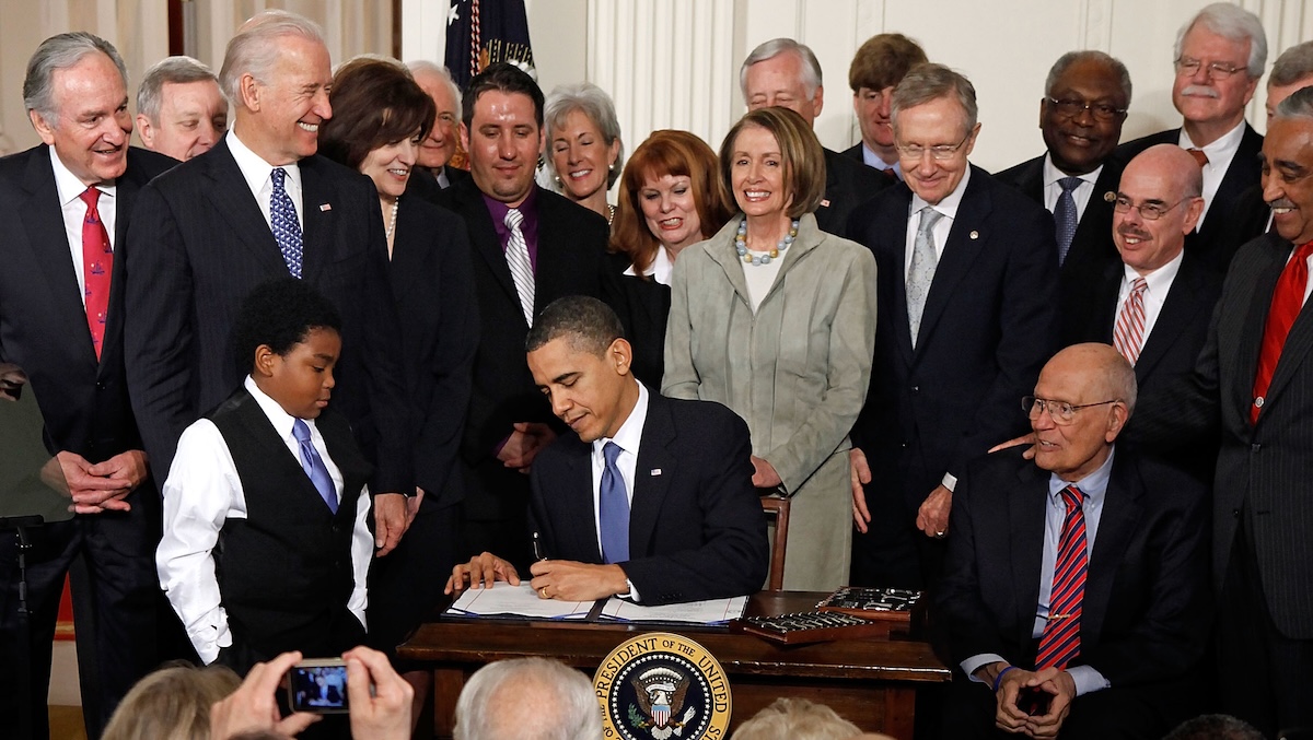 President Barack Obama signs the Affordable Health Care for America Act during a ceremony with fellow Democrats in the East Room of the White House on March 23, 2010 in Washington, DC.