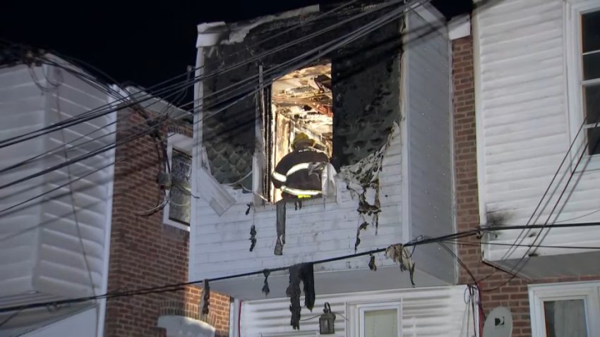 A firefighter can be seen working inside a rowhome in Olney that was damaged by a fire overnight.