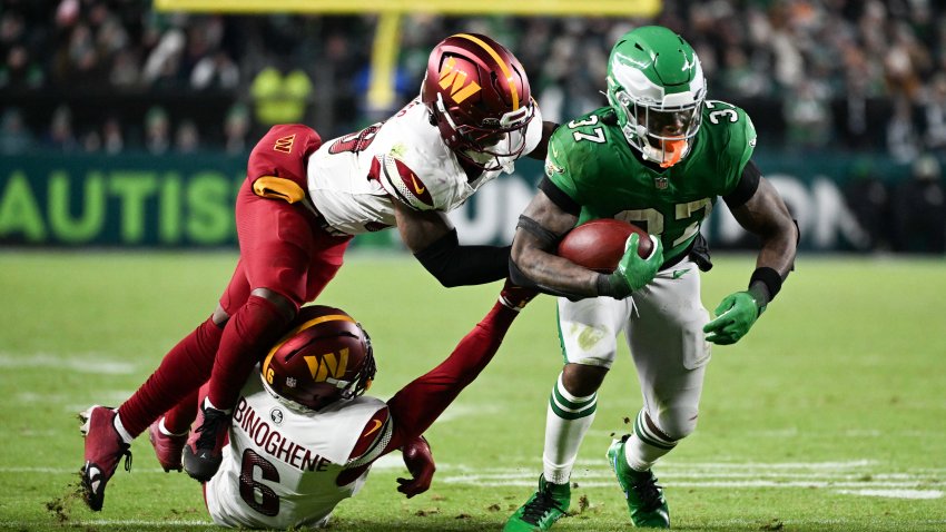 Jan 4, 2026; Philadelphia, Pennsylvania, USA; Philadelphia Eagles running back Tank Bigsby (37) rushes and is tackled by Washington Commanders cornerback Noah Igbinoghene (6) and Washington Commanders safety Jeremy Reaves (39) during the fourth quarter at Lincoln Financial Field. Mandatory Credit: Eric Hartline-Imagn Images